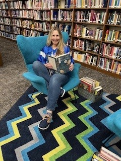 Mrs. West, books, rug, chair